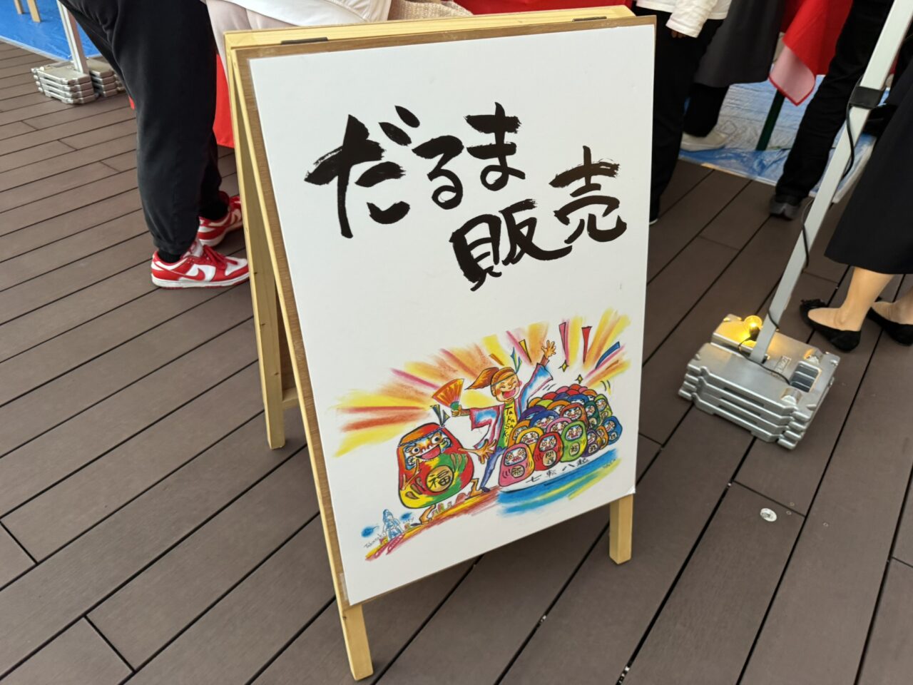だるま販売と書かれた手描きのイラスト入りスタンド看板
