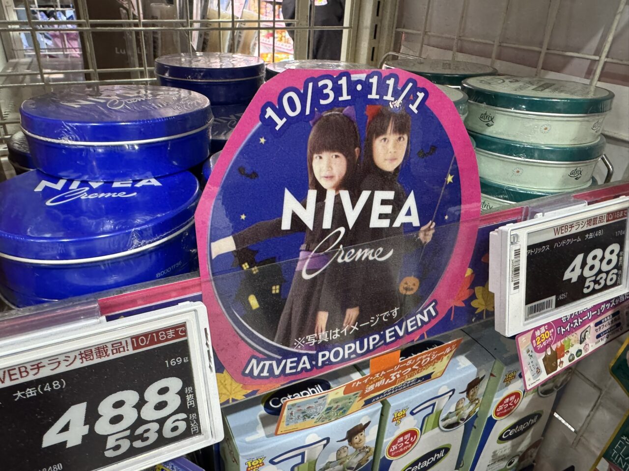 ドラッグストアの売り場に設置されたニベア缶ポップアップイベントの案内。ハロウィン仮装の姉妹の写真が入ったオリジナルニベア缶のイメージPOP