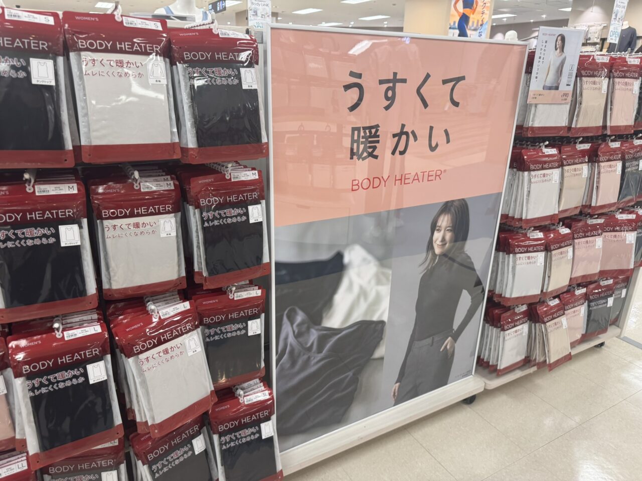 「うすくて暖かい BODY HEATER」の大きなパネルと、整然と並べられた冬用あったかインナーのパッケージ売り場