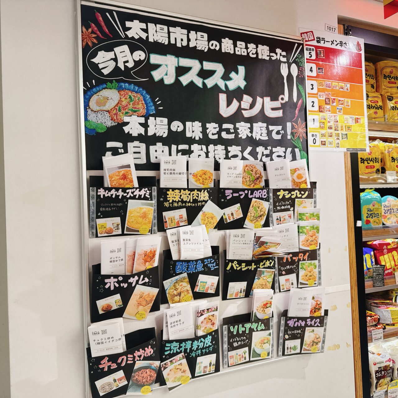 亜州太陽市場吉祥寺店の壁面に掲示された「今月のオススメレシピ」ボード。キムチチヂミやガパオライスなどのレシピカードと韓国ラーメン辛さ表