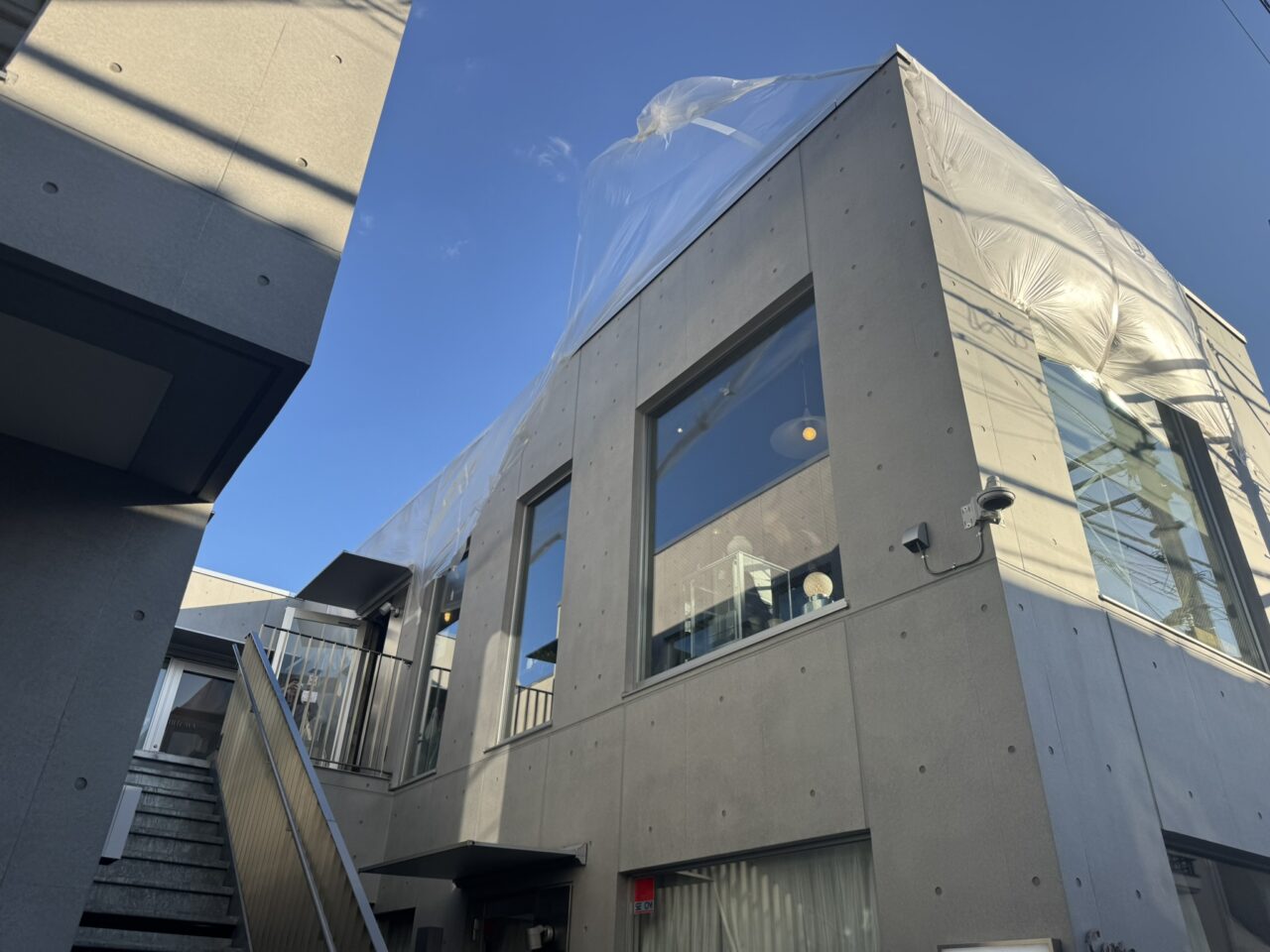 ビル1階の案内板。手描き風のハートロゴが入った「IUIE TOKYO」の電飾看板