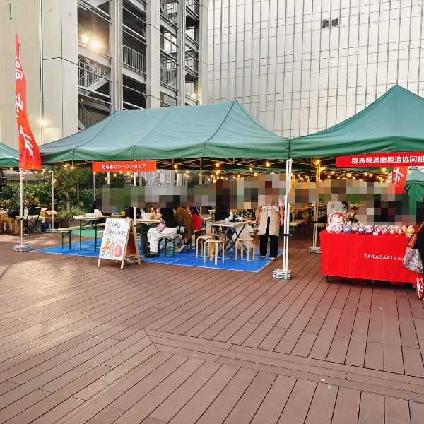 コピス吉祥寺A館3階GREENING広場で開催されたイベント会場の様子。緑のテントが並び、だるまのワークショップや販売に集まる来場者たち