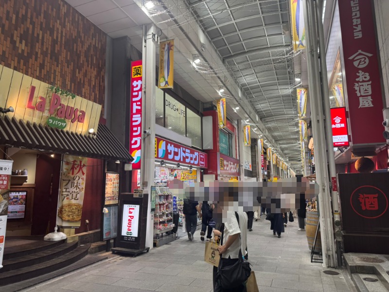 吉祥寺サンロード商店街の風景。多くの人で賑わう通り沿いにあるサンドラッグの赤い看板と店頭