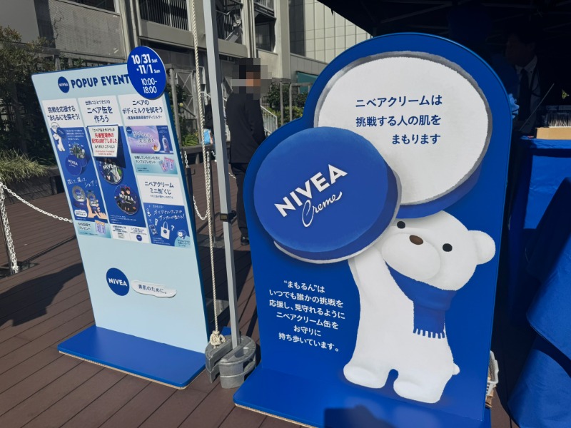 ニベア缶を持った白くま「まもるん」のイラスト看板とイベント案内パネル